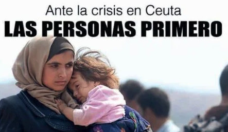 Cartel «Ante la crisis en Ceuta, las personas primero»: una mujer abraza a una niña dormida